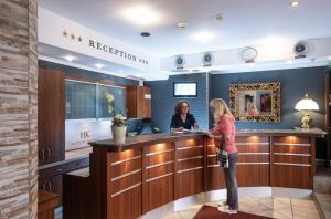 two women standing at a bar in a hotel lobby at Hotel Kufsteinerhof in Kufstein