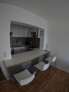 eine Küche mit weißen Stühlen und einer Arbeitsplatte in der Unterkunft Moderne 3 Zi Ferienwohnung in Winterberg