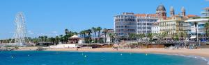 a view of a beach with buildings and the ocean at Superbe Appartement FREJUS PLAGE in Fréjus
