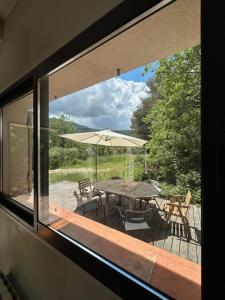 - une vue sur la terrasse dotée d'une table et d'un parasol dans l'établissement Maison dans écrin de verdure vue Sainte-Baume, à Nans-les-Pins