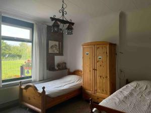 een slaapkamer met 2 bedden en een groot raam bij Charming authentic renovated farm in Cadier en Keer