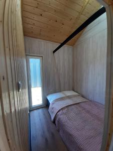 ein Schlafzimmer mit einem Bett in einem Zimmer mit einem Fenster in der Unterkunft Wypoczynkowo Domki Letniskowe in Mikołajki