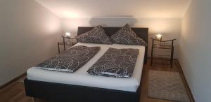 ein Schlafzimmer mit einem Bett und zwei Kissen in der Unterkunft Pension Strohm im Lieth Café in Bad Fallingbostel + 42 Fotos