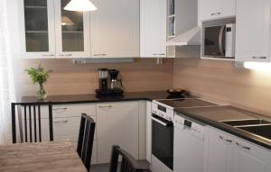 a kitchen with white cabinets and a stove top oven at Norppa Resort in Savonlinna