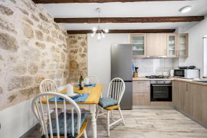 a kitchen with a wooden table and chairs in a room at House AnaDora with pool - Zlarin in Zlarin