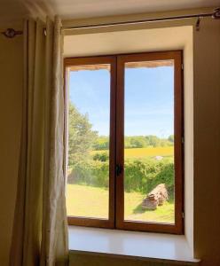 a window with a view of a green field at Millstone Gite 2, two bed apartment + shared pool in Chassenon