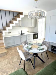 una cocina con mesa y sillas y una escalera en D&A Apartamentai en Palanga