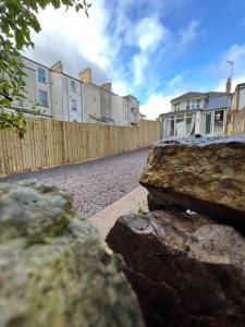 una cerca y algunas rocas delante de un edificio en MAISON DE VACANCES, en Newport