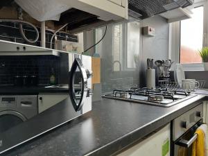 cocina con fogones y fogones horno superior en MAISON DE VACANCES en Newport