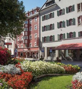 a street with flowers and buildings in a city at Hotel Kufsteinerhof in Kufstein