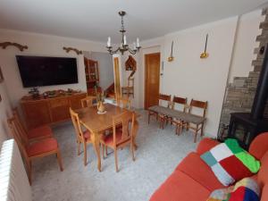 ein Wohnzimmer mit Tisch, Stühlen und Fernseher in der Unterkunft VUT Corea324 in Caboalles de Abajo