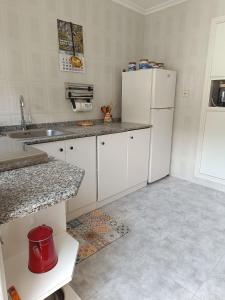 a kitchen with white cabinets and a white refrigerator at VUT Corea324 in Caboalles de Abajo