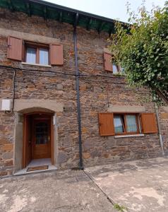 - un bâtiment en briques avec une porte et des fenêtres dans l'établissement VUT Corea324, à Caboalles de Abajo