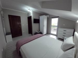 a bedroom with a large white bed and a window at Casa Leahu in Baile Unu Mai