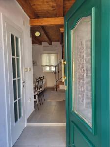 eine grüne Tür, die zu einem Flur mit Stühlen führt in der Unterkunft Mini Villa Punta in Zadar