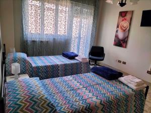- une chambre avec 2 lits et une chaise dans l'établissement New Dawn Apartment, Appartamento Turistico, casa vacanze, à Catane