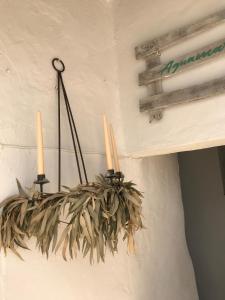 Una lámpara colgante con dos velas en una pared. en Casa Aguamarina, en Vejer de la Frontera