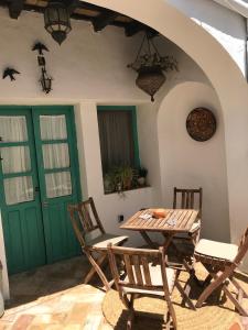 ベヘール・デ・ラ・フロンテーラにあるCasa Aguamarinaの緑のドア付きの部屋(テーブル、椅子付)