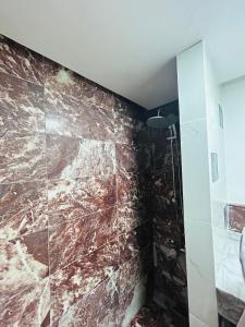 een badkamer met een bruine marmeren muur bij Résidence Mirador MAJORELLE in Marrakesh