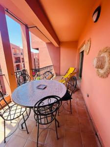 een patio met een tafel en stoelen op een balkon bij Résidence Mirador MAJORELLE in Marrakesh