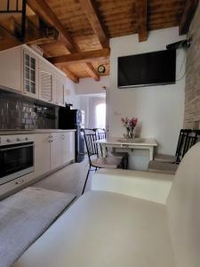 a kitchen with a table and a tv on the wall at Mini Villa Punta in Zadar