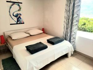 a bedroom with a bed with black pillows on it at Apartment Lozica with private garden, self check-in in Korčula