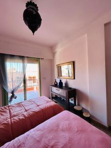 een slaapkamer met 2 bedden, een bureau en een raam bij Résidence Mirador MAJORELLE in Marrakesh