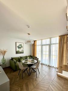 a living room with a green couch and a table at D&A Apartamentai in Palanga