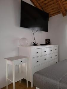 um quarto com uma cómoda branca e uma televisão na parede em Mini Villa Punta em Zadar