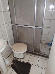 a bathroom with a toilet and a shower at Quarto privativo, banheiro externo. in Novo Hamburgo