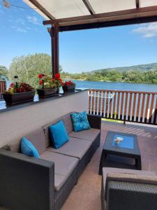 eine Couch auf einem Balkon mit Blick auf das Wasser in der Unterkunft Zen Apartment in Veliko Gradište