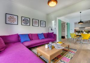 een woonkamer met een paarse bank en een tafel bij Bath Cottage in Saundersfoot