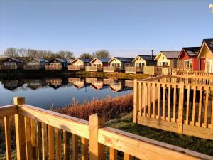 a row of houses next to a body of water at Low Lake Lodge - Lakeside - Part of the The Bay Filey Holiday Village with pool, gym and direct beach access, pub, restaurant, tennis and meadows walks in Reighton