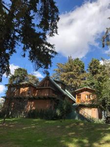 una casa sentada en la cima de un exuberante campo verde en La casa de los volcanes / Volcano House, 