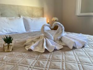 two towel swans making a heart on a bed at Eira do Cajado 