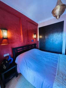 een slaapkamer met een bed en een rode muur bij Résidence Mirador MAJORELLE in Marrakesh