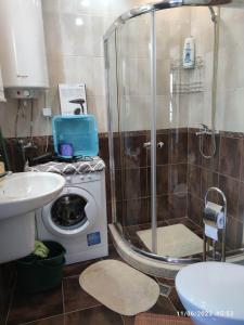 y baño con ducha y lavadora. en Apartament Piero en Pomorie