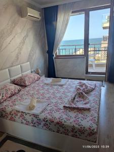 a bedroom with a bed with a view of the ocean at Apartament Piero in Pomorie