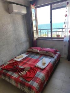 a bedroom with a bed with a view of the ocean at Apartament Piero in Pomorie