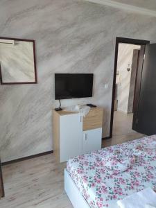 a bedroom with a bed and a flat screen tv at Apartament Piero in Pomorie