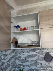 a cupboard with plates and dishes in it at Apartament Piero in Pomorie
