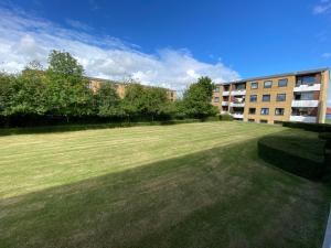 a large grassy field in front of a building at Stor 2 værelses lejlighed in Randers