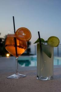 a drink and a vase with an orange slice at Villa Koukounaria in Skopelos Town