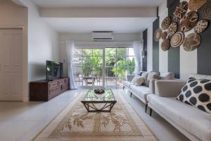 a living room with a couch and a table at Oasis townhouse in the perfect location in Bangkok