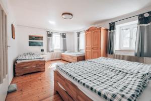 1 dormitorio con 2 camas, suelo de madera y ventanas en Hüdahof Niemtal en Niemthal