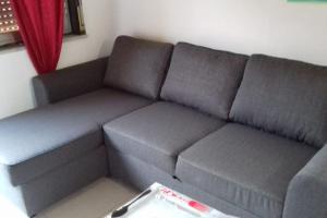 ロッカルメーラにあるCASA VACANZA ROCCALUMERA (ME)の赤いカーテンのかかった部屋にある灰色のソファ +10枚の写真