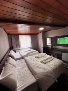 Gold Corner Hotel في إسطنبول: غرفة نوم بثلاث اسرة وتلفزيون بشاشة مسطحة