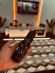 a person holding a remote control in a kitchen at Apartman Podroom in Kraljevo