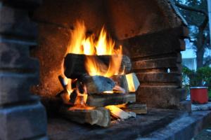a large brick oven with fire in it at Little house Kućica in Banjol