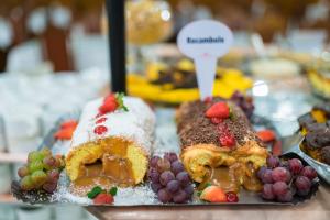 a plate of food with fruit and pastries on it at Hotel Negreiros in São Lourenço